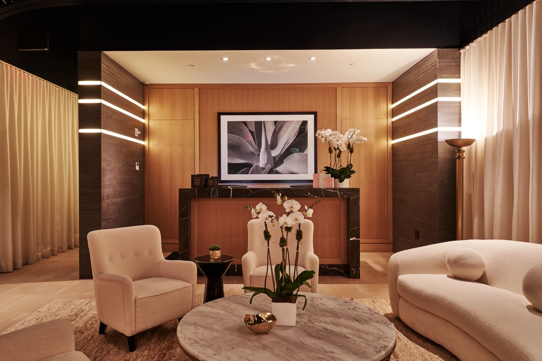 A living room with a couch , chairs , a table and a television.