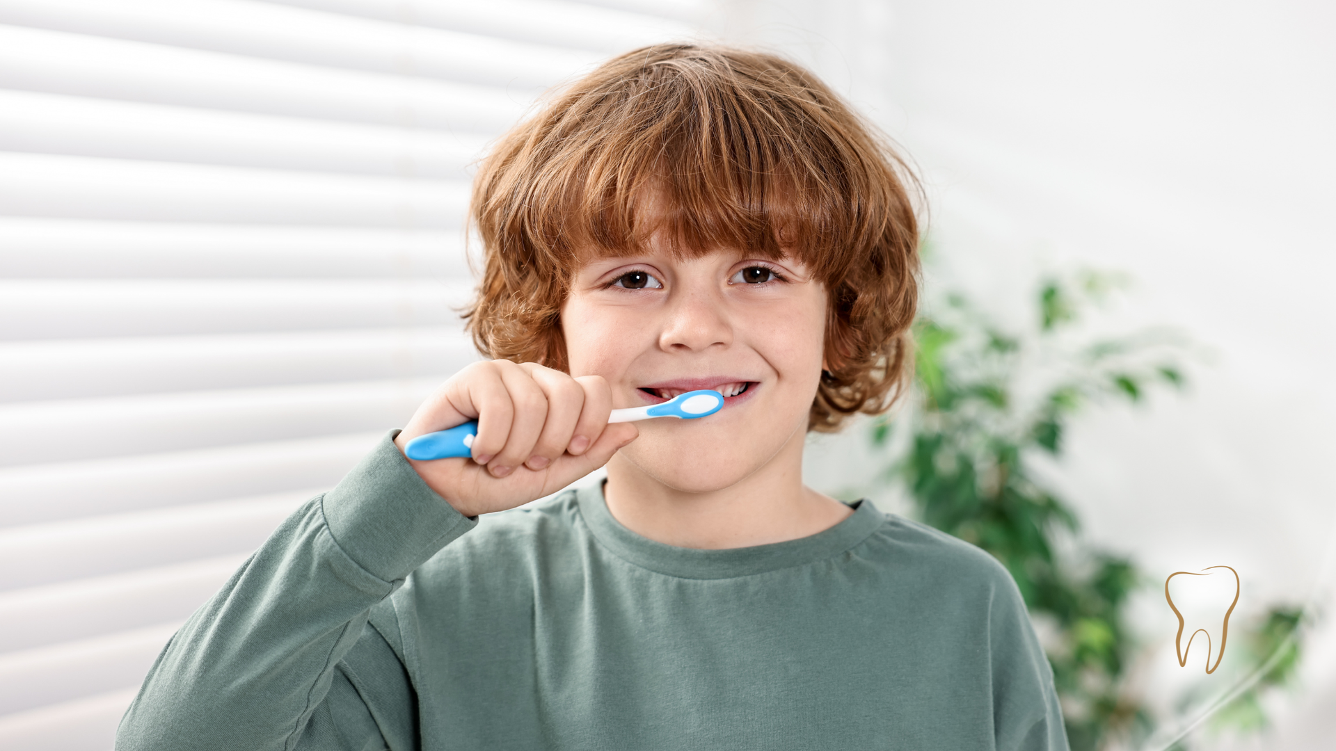 Boy with curly red hair brushing his teeth with a blue toothbrush in front of a window.
