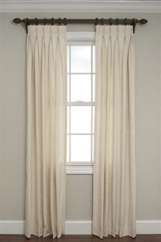 A pair of white curtains are hanging on a window.