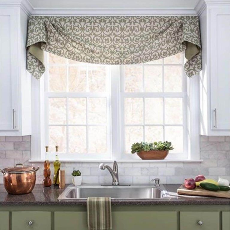 A kitchen with a sink and a window with a curtain over it