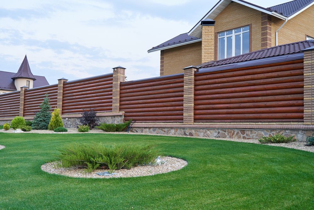Lawn in Front of a House With a Decorative Brown and Stone Fence — NQ Prefab Concrete Products Pty Ltd in Cardwell, QLD