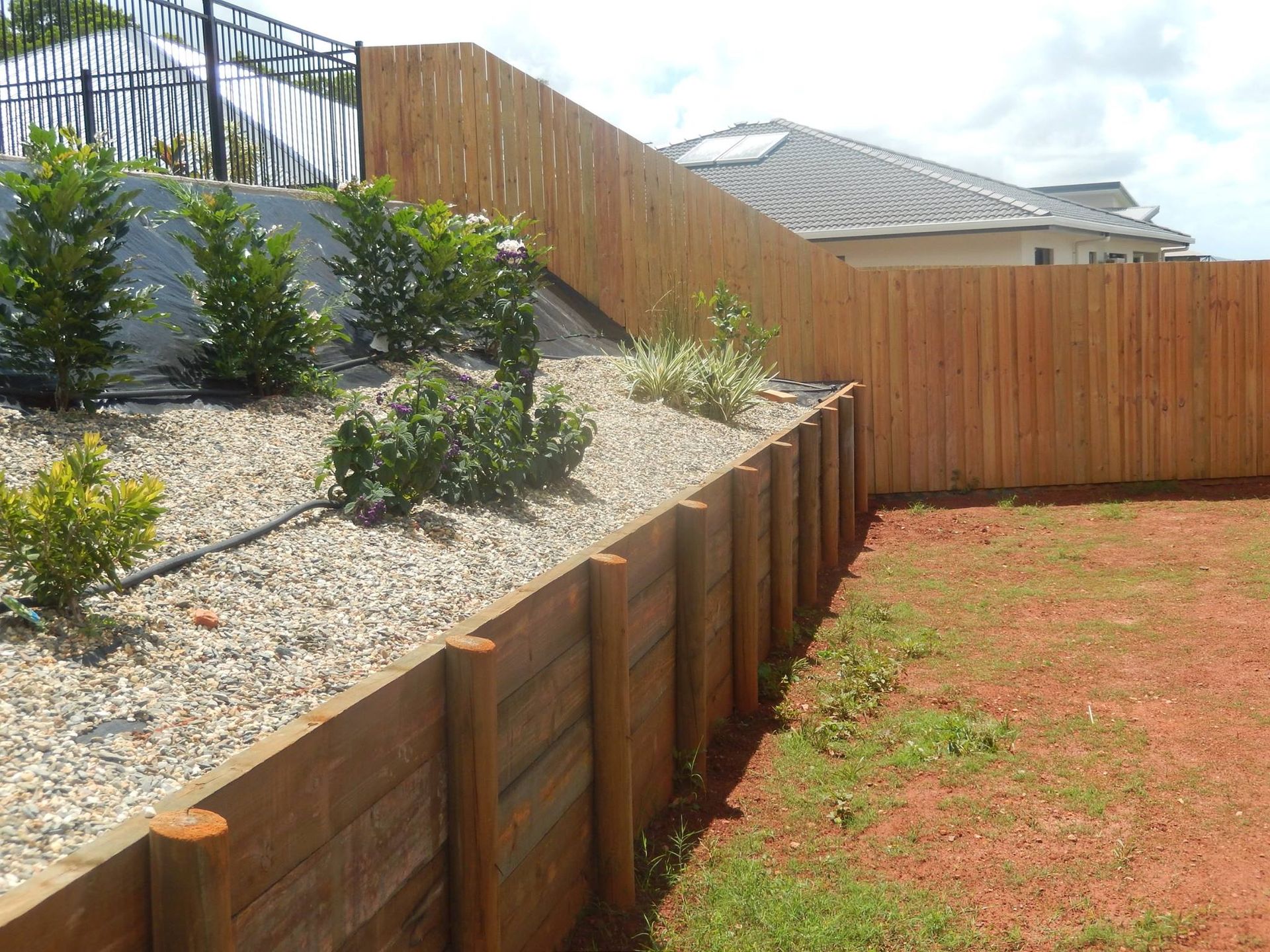 Wooden Retaining Wall and Fence in a Backyard — NQ Prefab Concrete Products Pty Ltd in Coconuts, QLD
