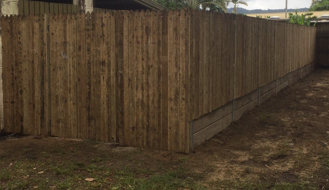 Wooden Privacy Fence in a Yard, Dark Brown Planks — NQ Prefab Concrete Products Pty Ltd in Cairns, QLD