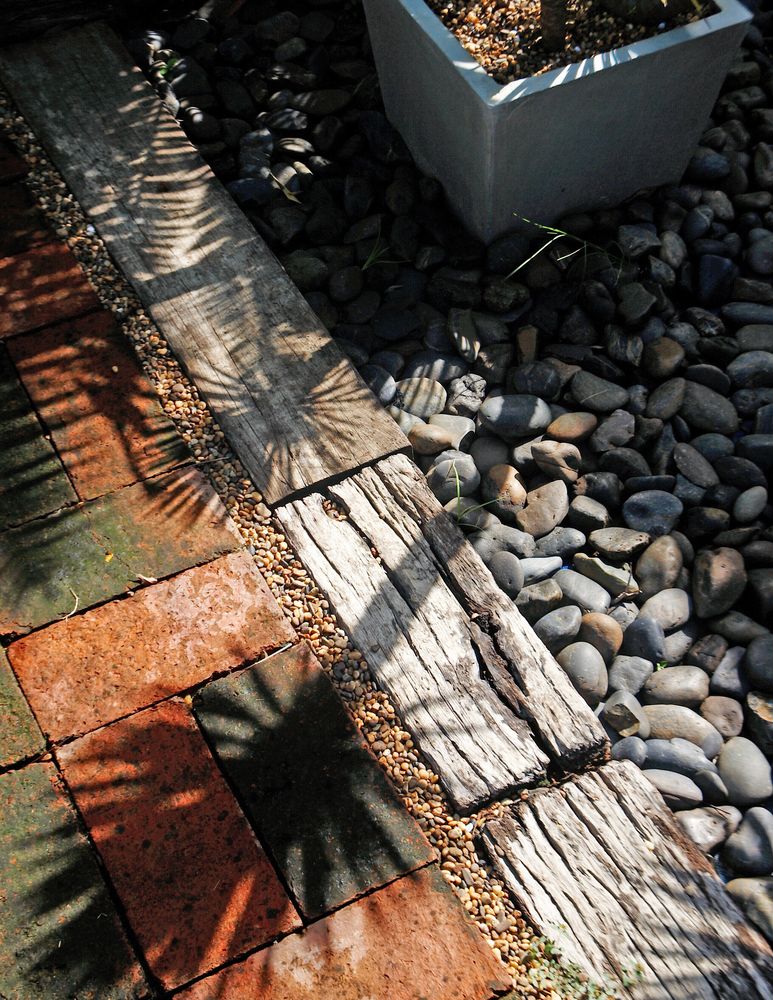 Brick Patio With Wooden Planks and Pebbles — NQ Prefab Concrete Products Pty Ltd in Tully, QLD
