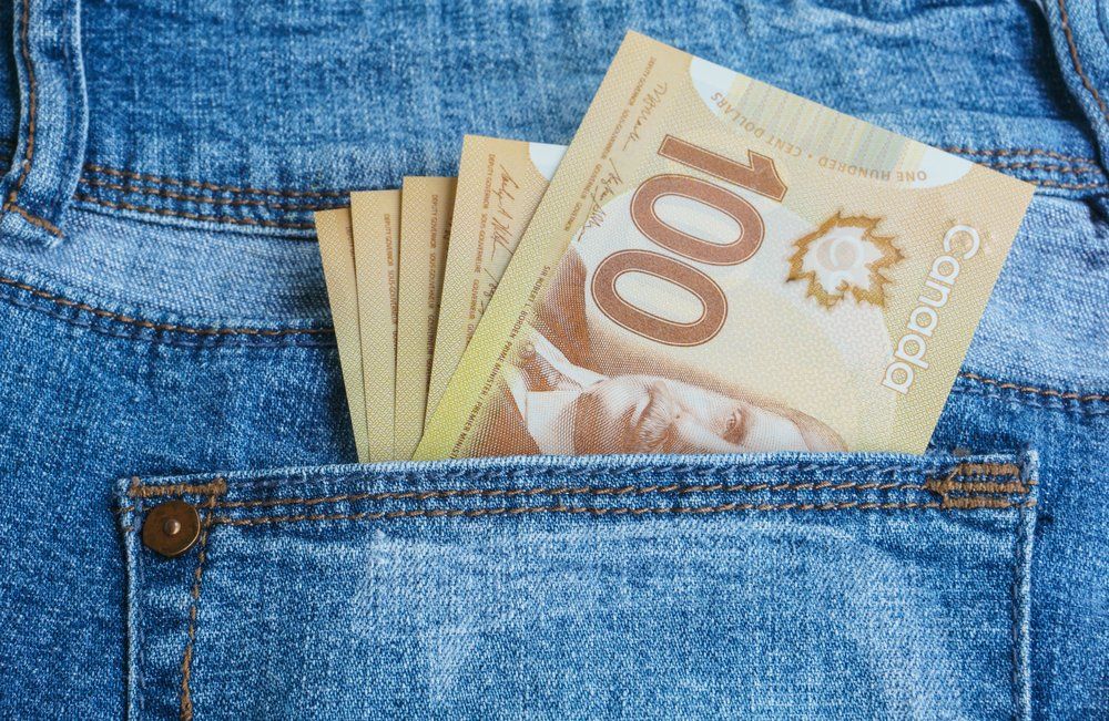 Canadian $100 bills in a blue jean pocket.