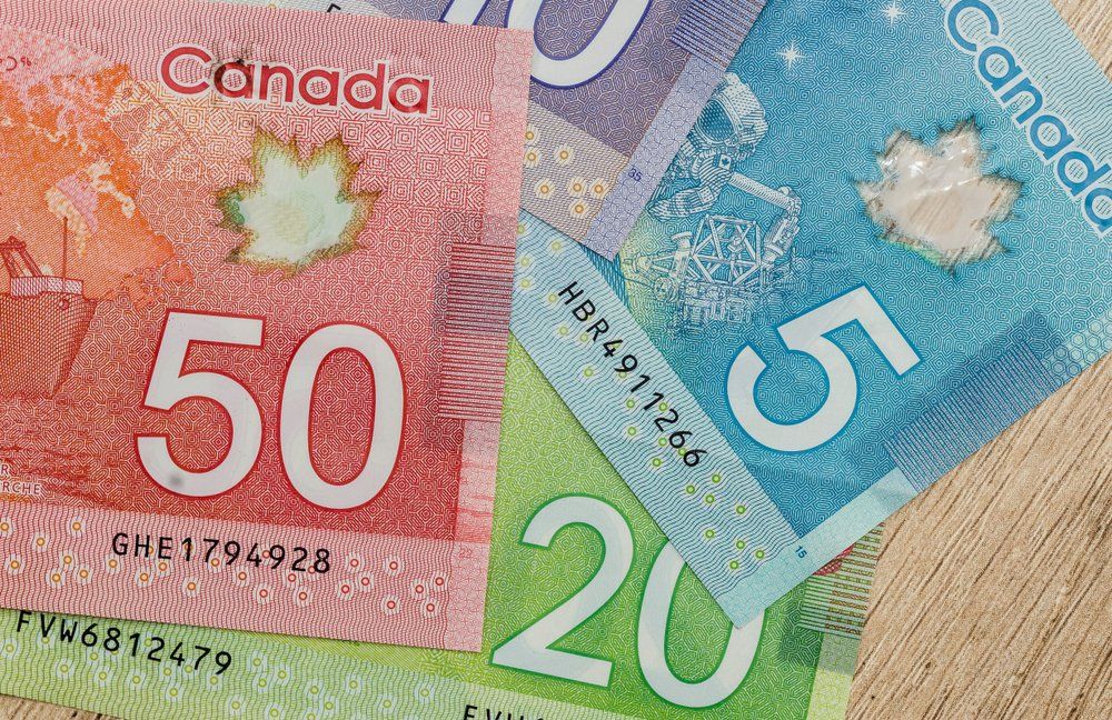 Canadian currency bills: $50 red, $5 blue, and $20 green.