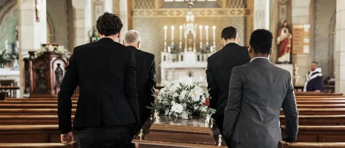 Pallbearers carrying casket into church for service at funeral home and cremations Covington, LA