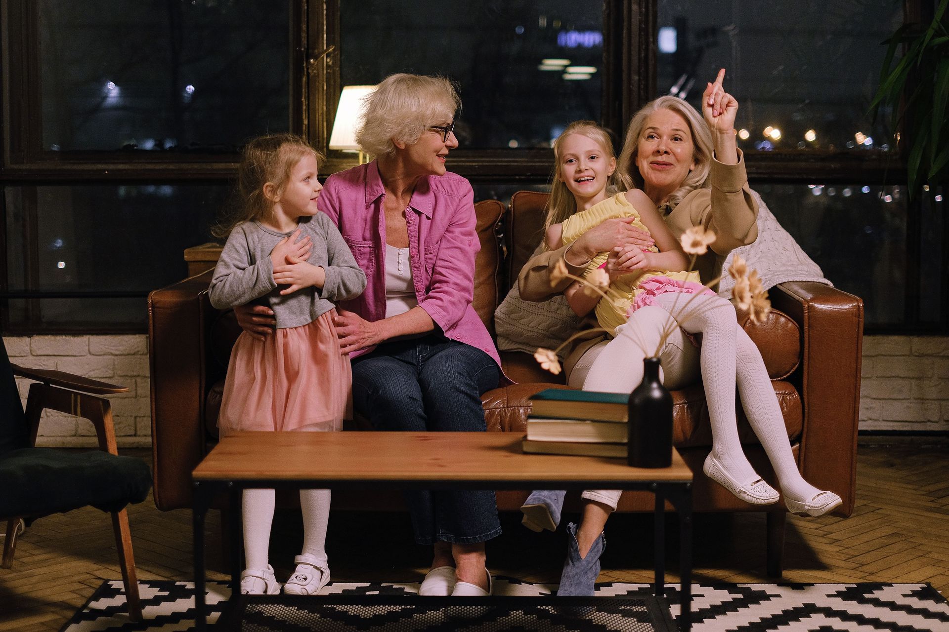 Family sitting on a couch in a cozy living room, smiling and talking together