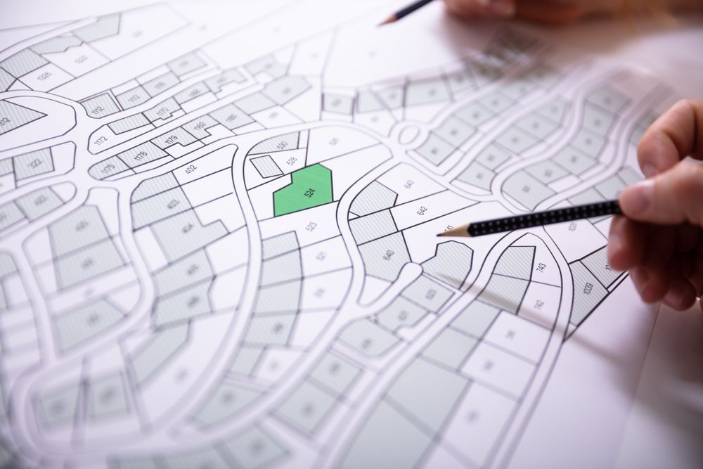 Hand Holding a Pencil Over a Detailed Site Plan — Adamson Town Planning in Noosaville, QLD