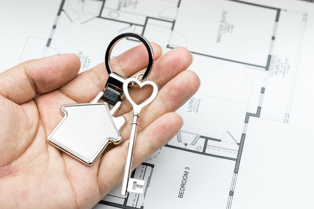 Hand Holding a House Key — Adamson Town Planning in Noosaville, QLD