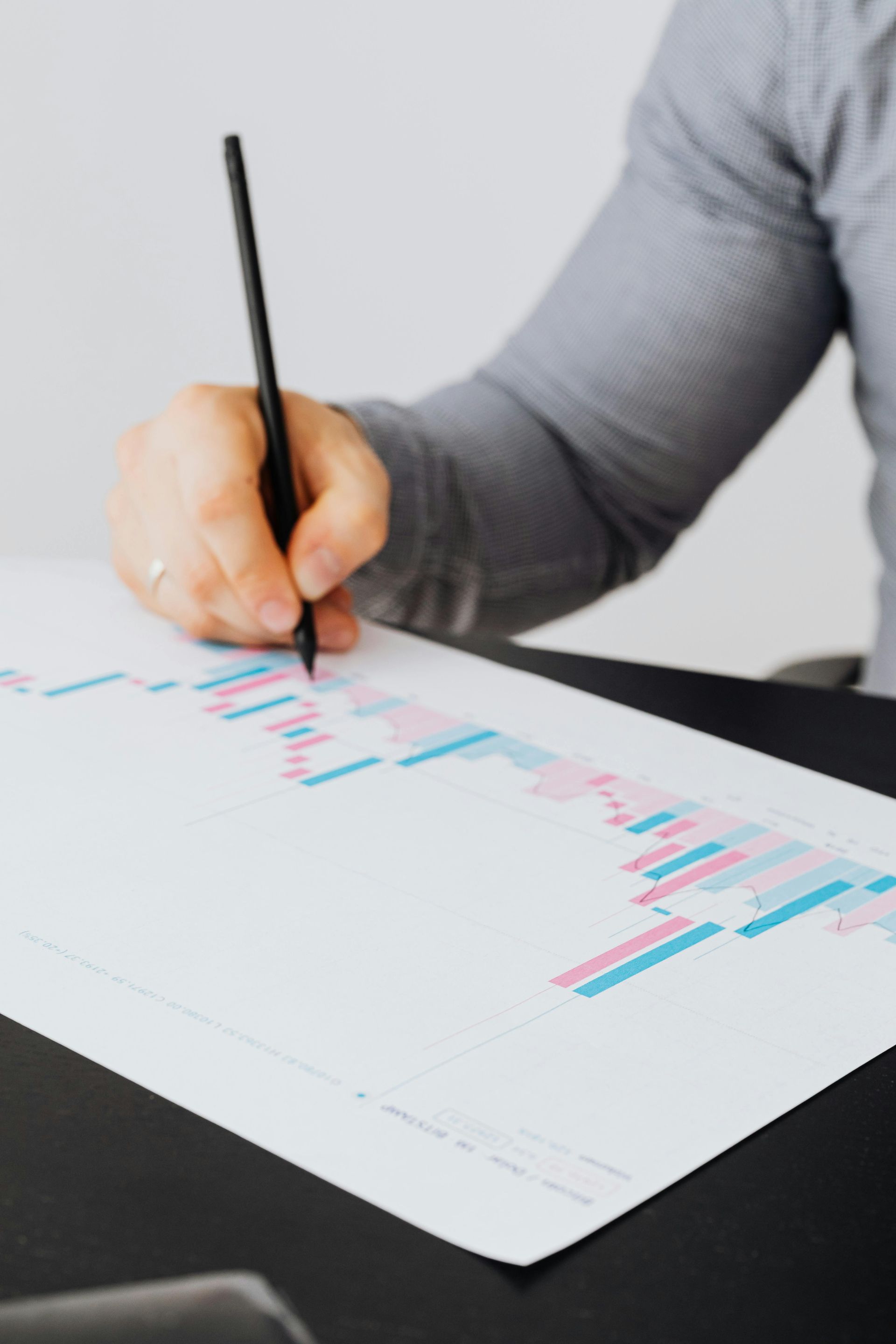 Woman Pointing to a Chart, Presenting to Two Colleagues in an Office — Adamson Town Planning in Noosaville, QLD