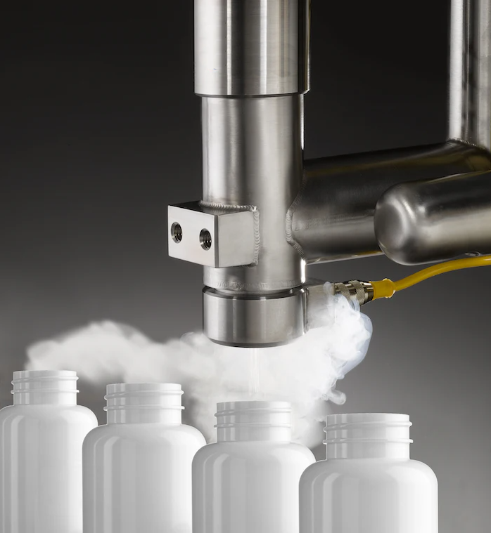 Arow of white bottles are being filled by a machine