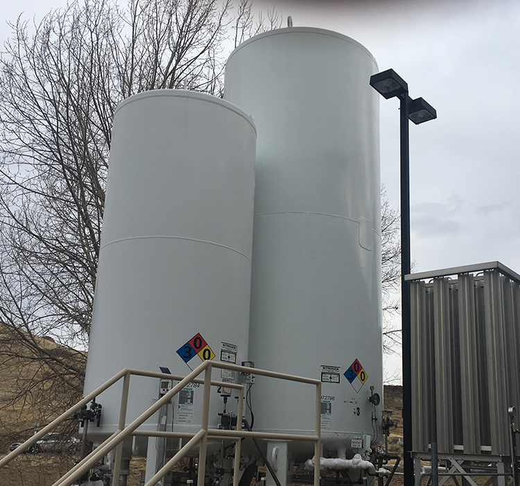 Large white tanks with warning signs on them