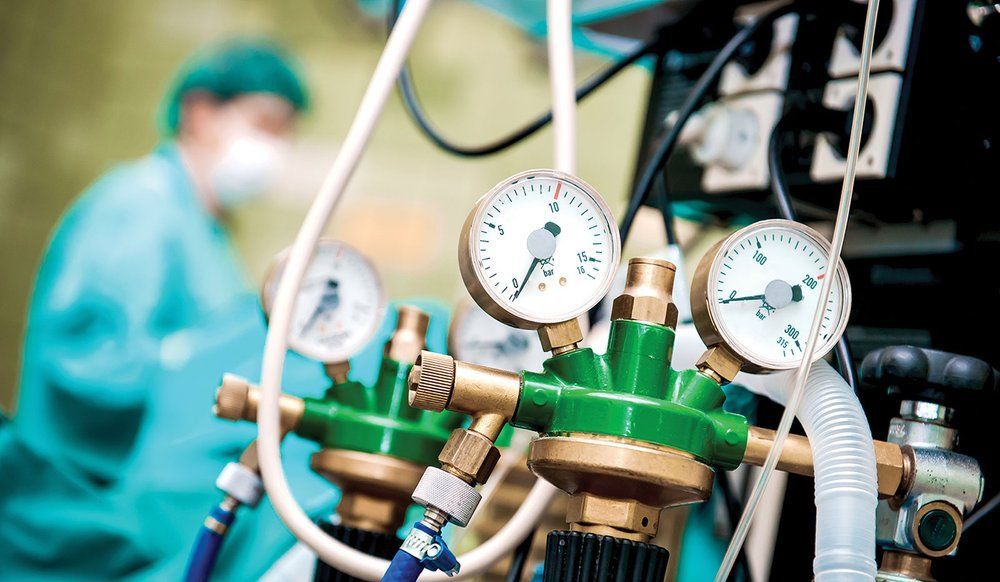 A close up of a medical device with a surgeon in the background