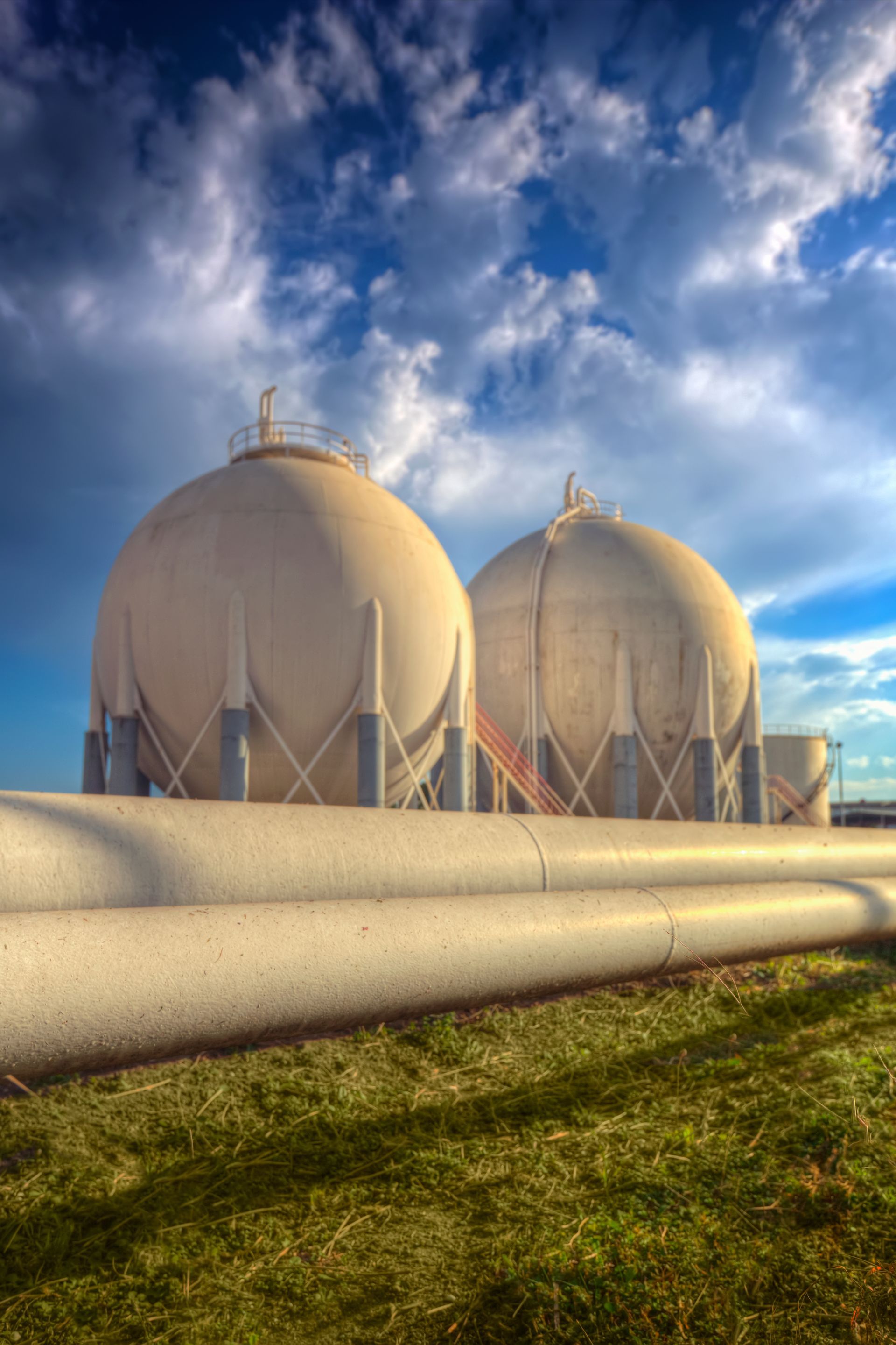 A couple of gas tanks sitting next to each other in a field