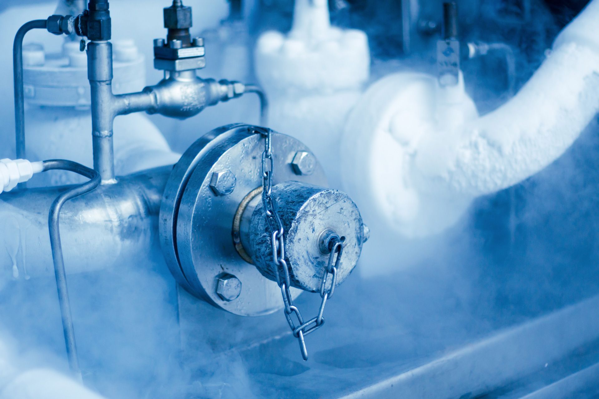 A close up of a pipe with smoke coming out of it in a factory