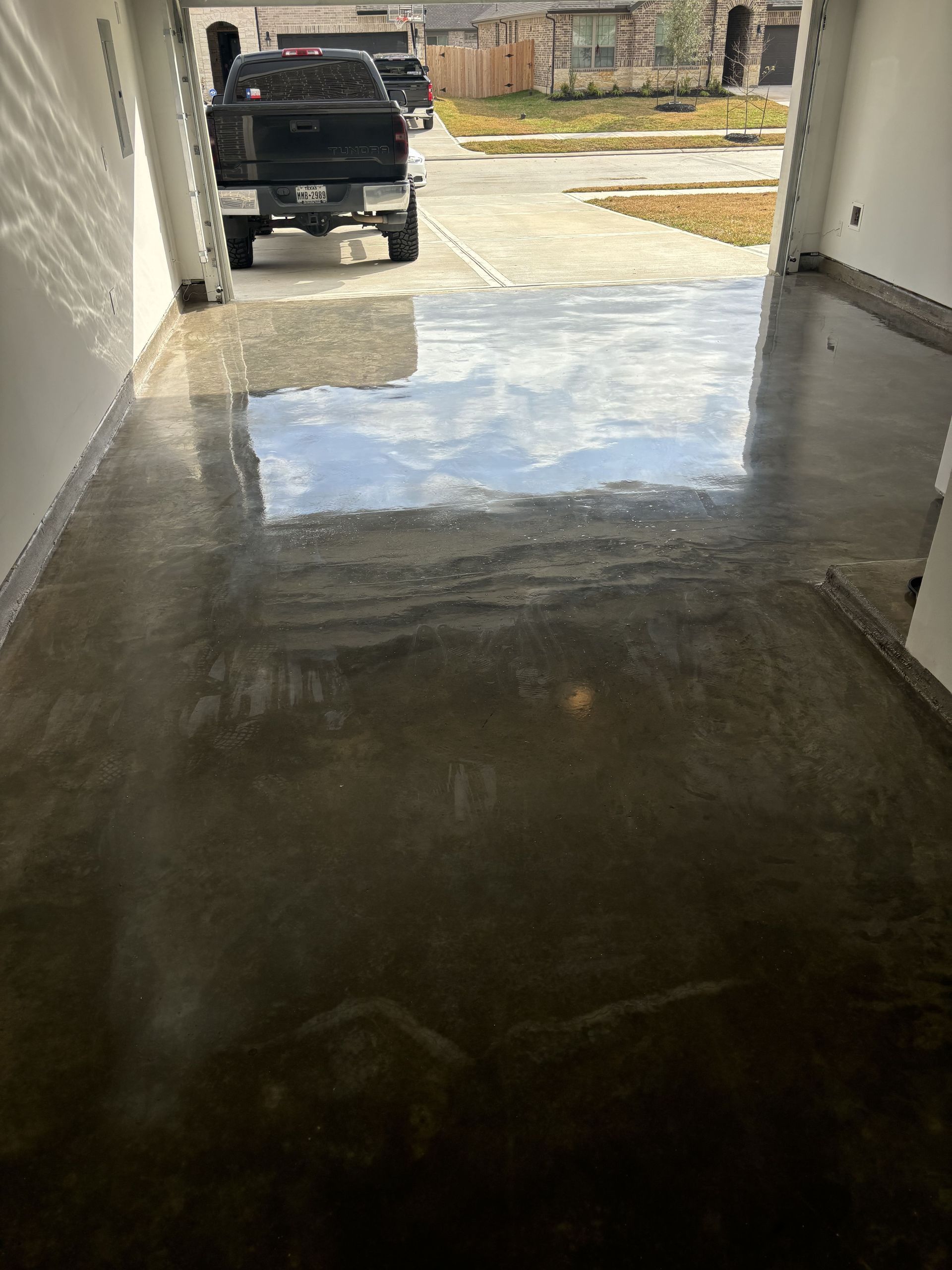 Polished concrete garage floor reflecting sky and parked truck.