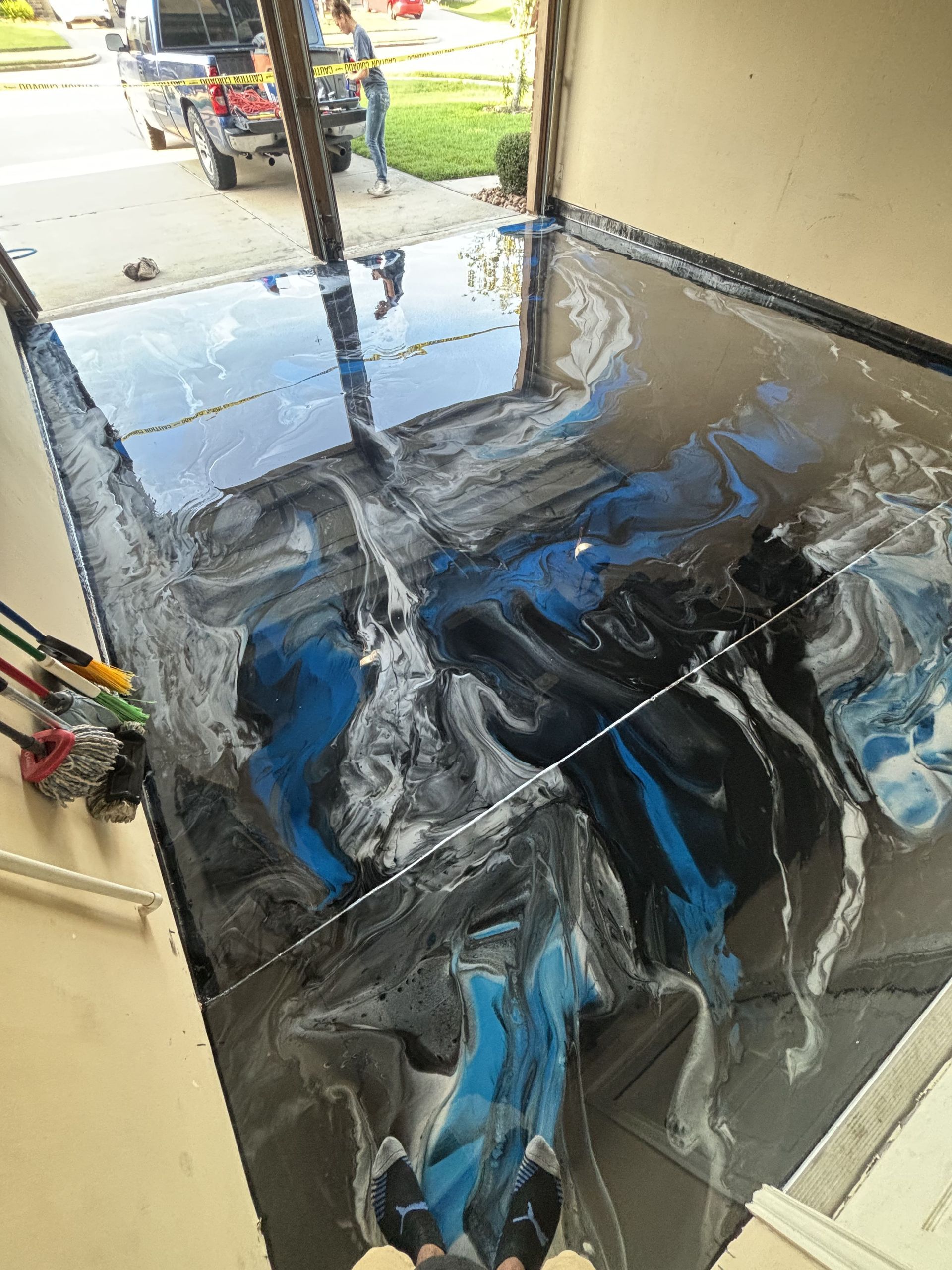 Garage floor with a blue, black, and silver epoxy finish.