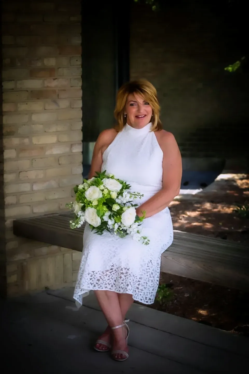 woman in white dress holding bouquet