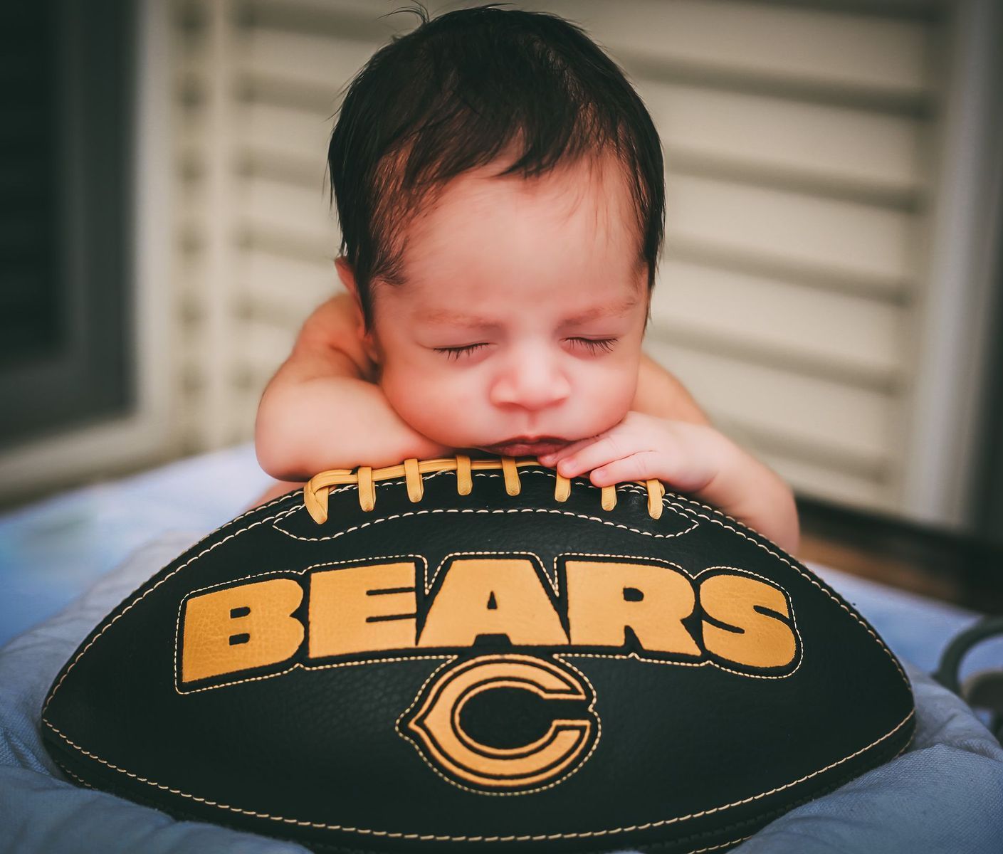 Newborn rests on Chicago Bears football.