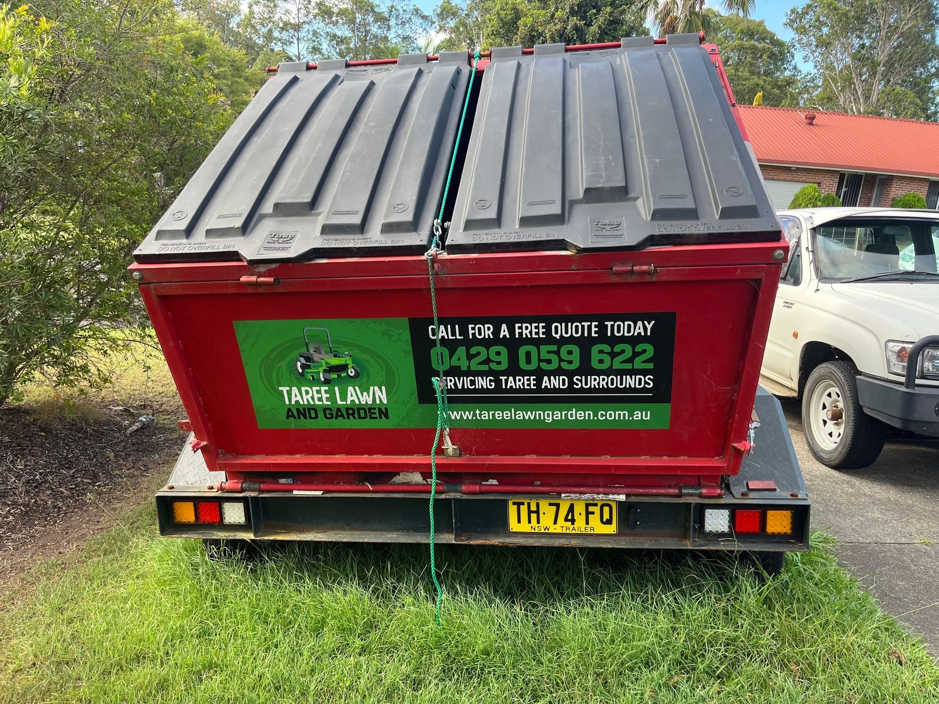 Red Dumpster on a Trailer With a Phone — Taree Lawn and Garden In Taree, NSW