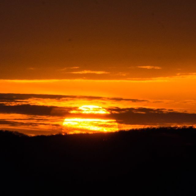 A sunset with the sun shining through the clouds