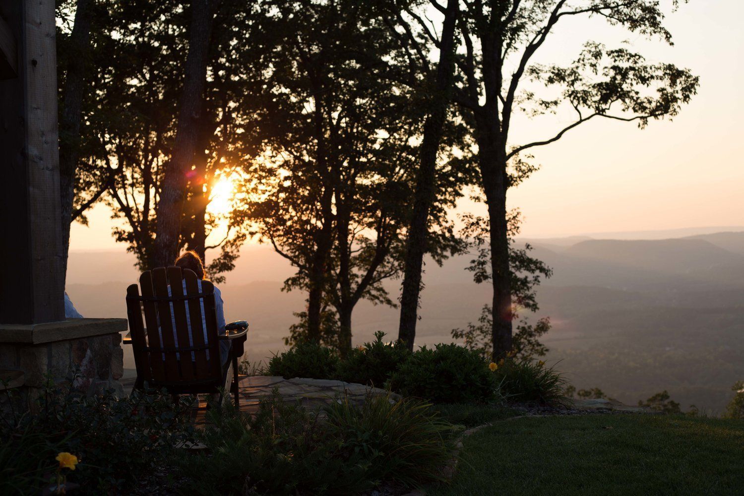 A person sitting in a chair looking at the sunset