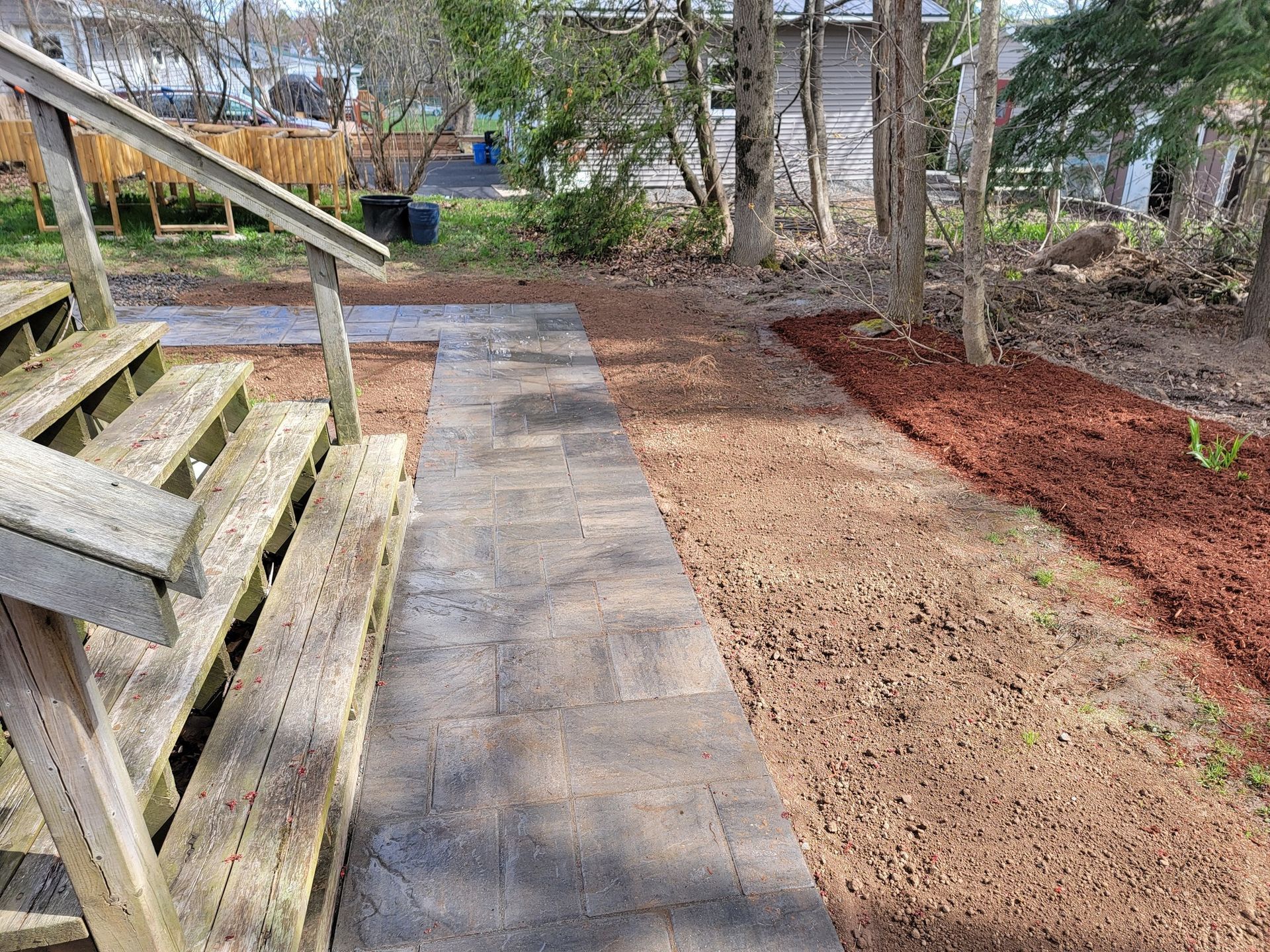 A wooden deck with stairs and a walkway in the backyard.