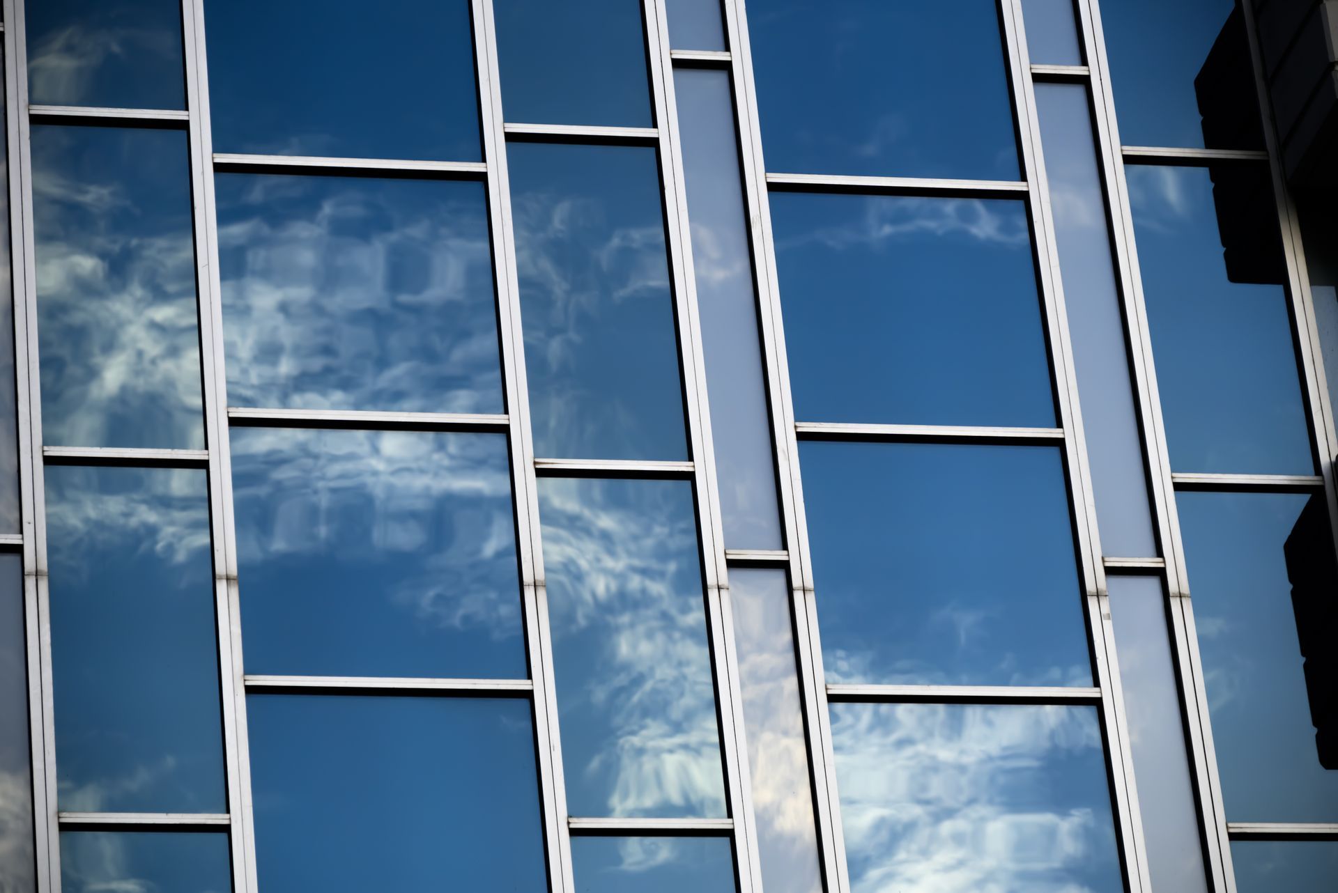 Reflective blue glass windows on a modern building facade against the sky