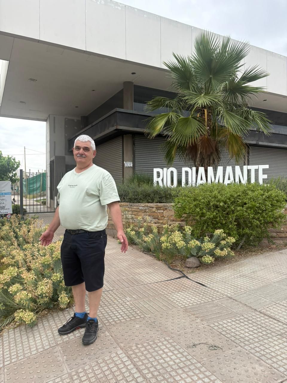 Hombre de pie frente al cartel de