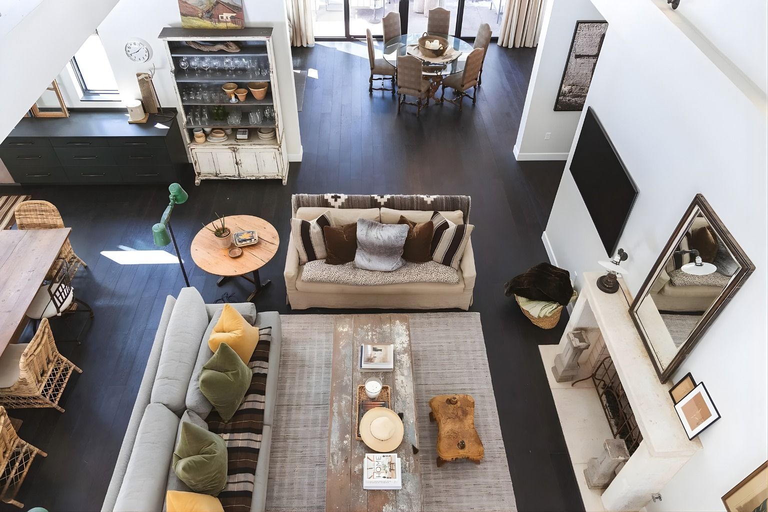 Overhead view of a modern living room with sofa, rug, TV, and dining area beyond.