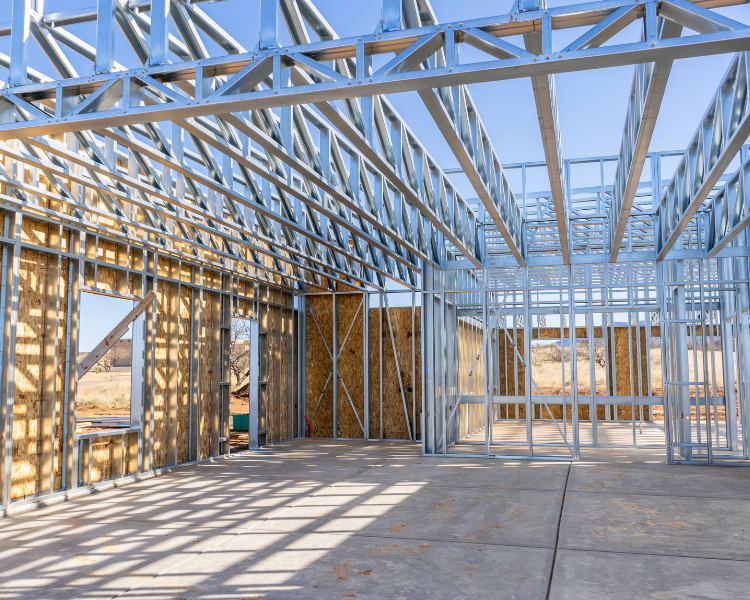 Steel framing under construction inside a sunlit building foundation.