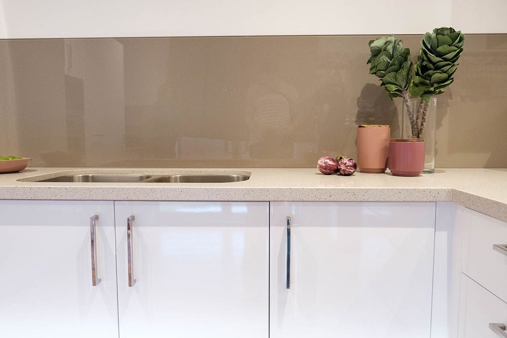A Kitchen With White Cabinets, a Sink, and a Plant on the Counter — Flow Kitchens in Harrington, NSW