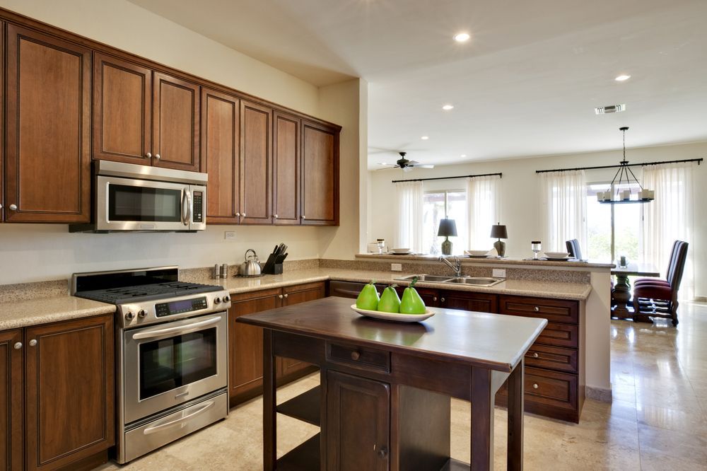 A Kitchen With Stainless Steel Appliances and Wooden Cabinets — Flow Kitchens in Wingham, NSW