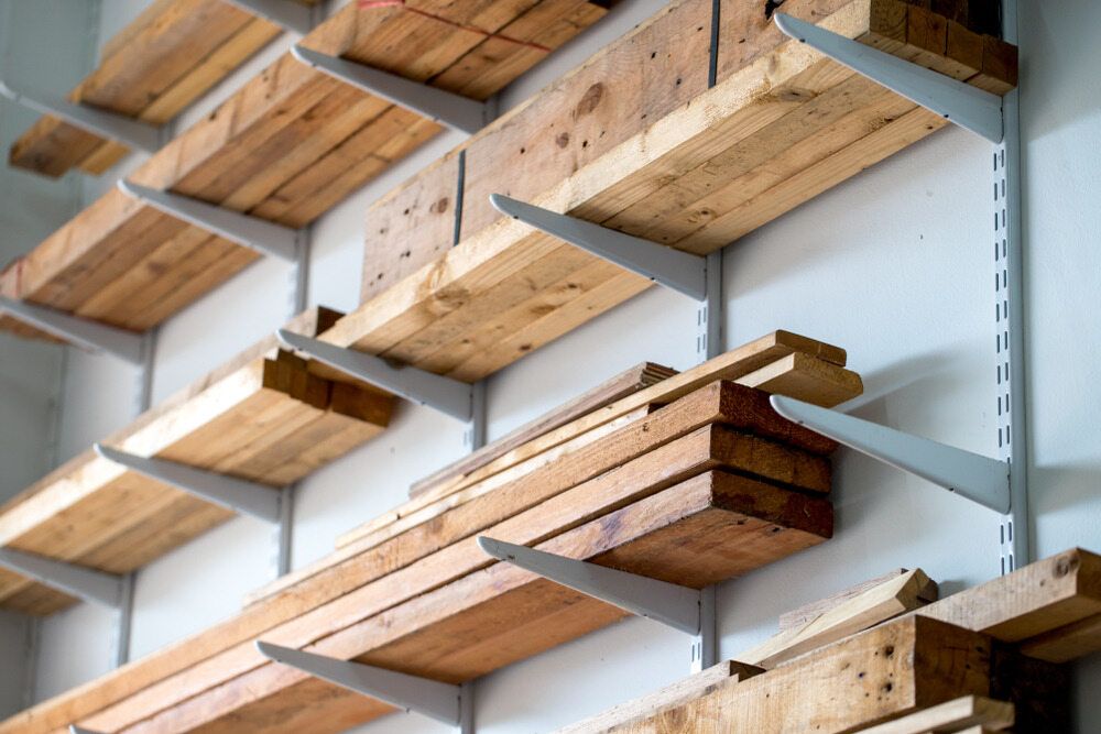 A Shelf Filled With Wooden Boards on a Wall — Flow Kitchens in Taree South, NSW