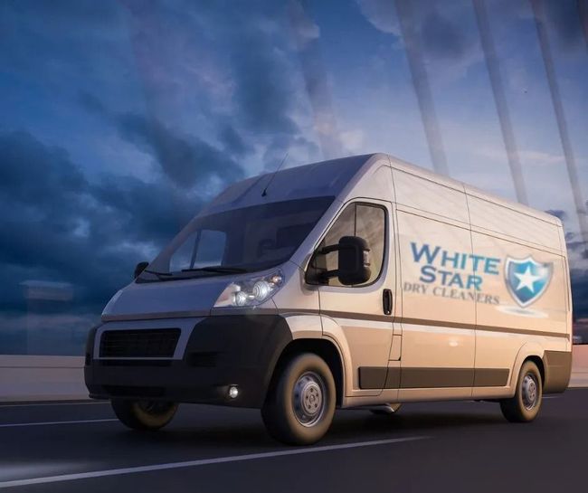 White Star Dry Cleaners van driving on road with a cloudy sky.