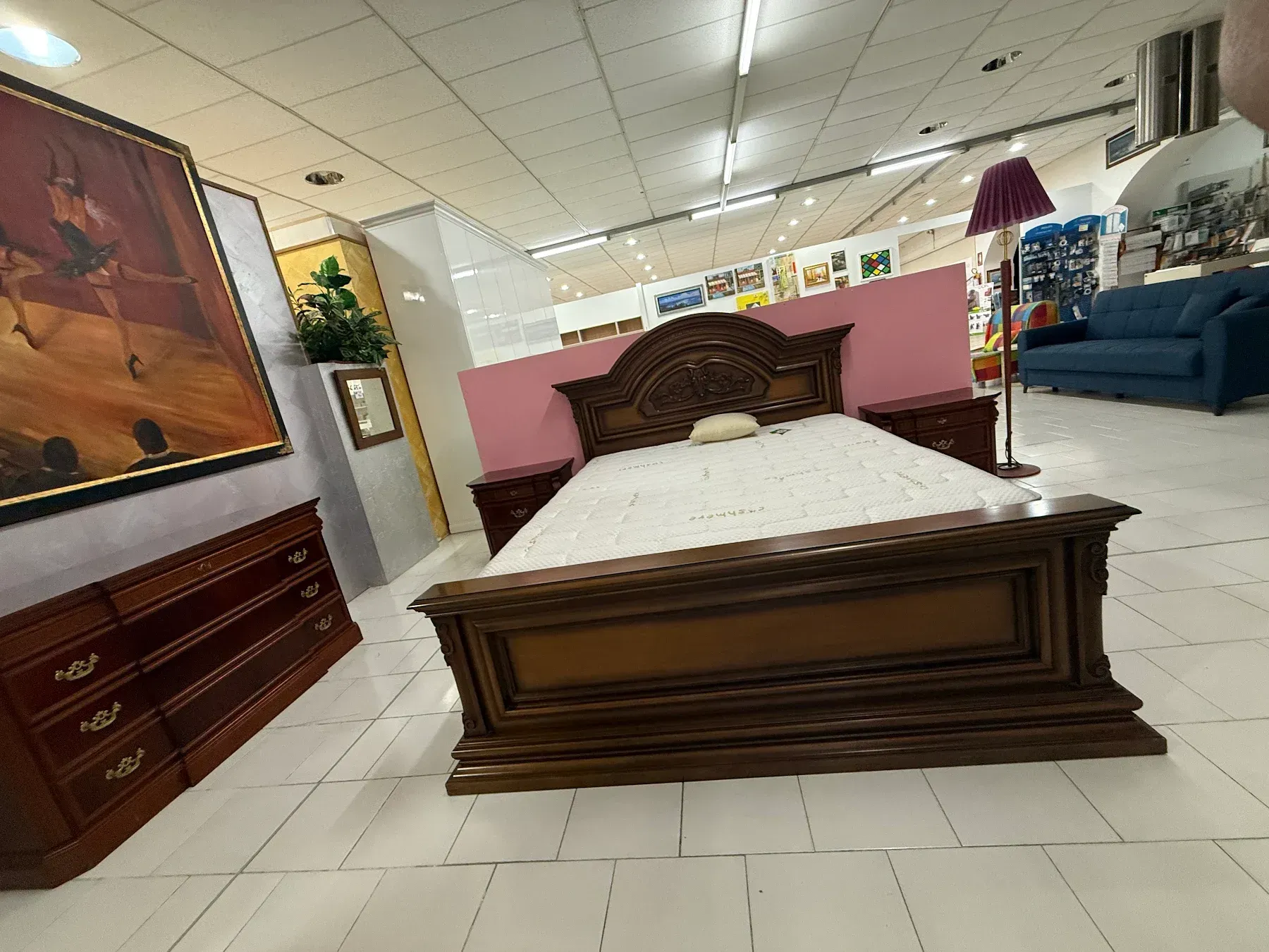 Letto in legno scuro decorato con lenzuola bianche e comodini abbinati.