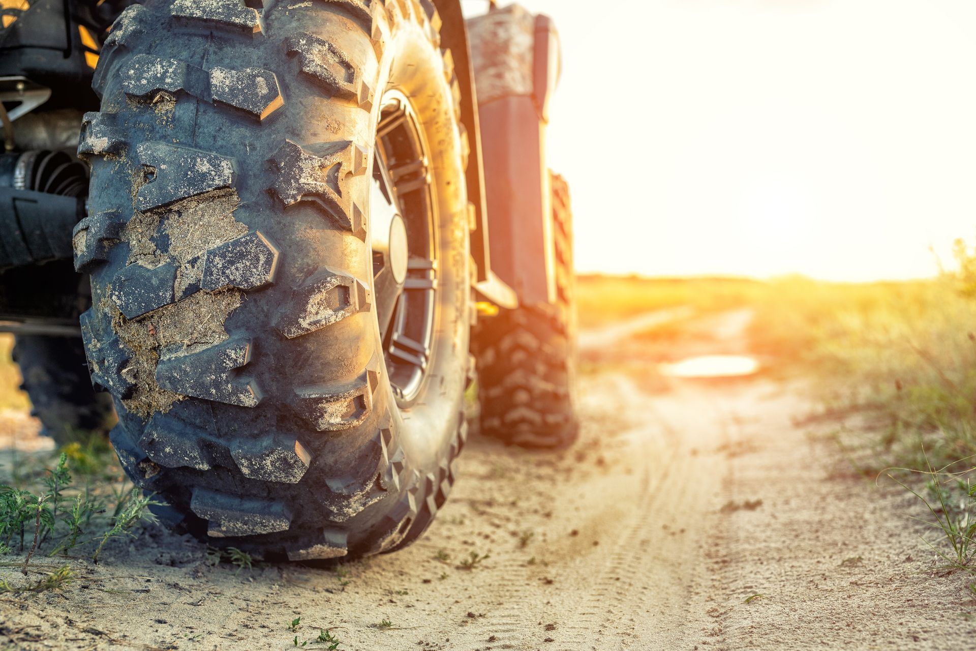 A close up of a tire on a dirt road.