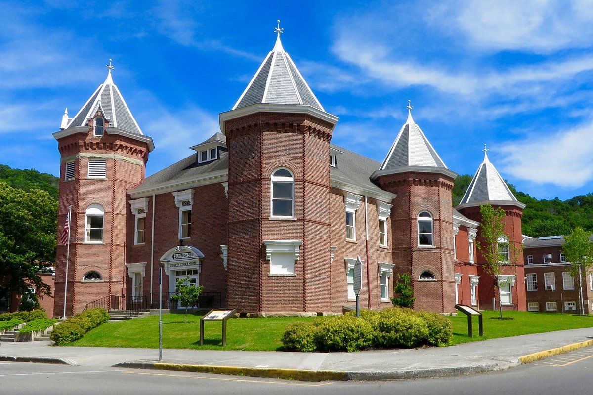 A large red brick building with three towers on top of it.
