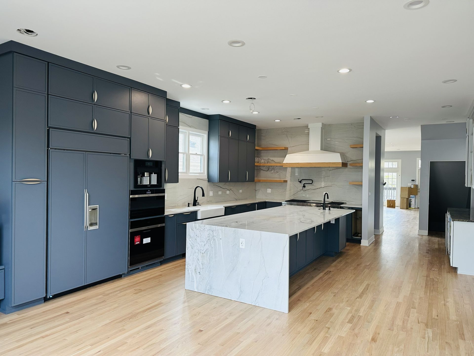 modern kitchen featuring navy blue cabinetry and a large white marble island