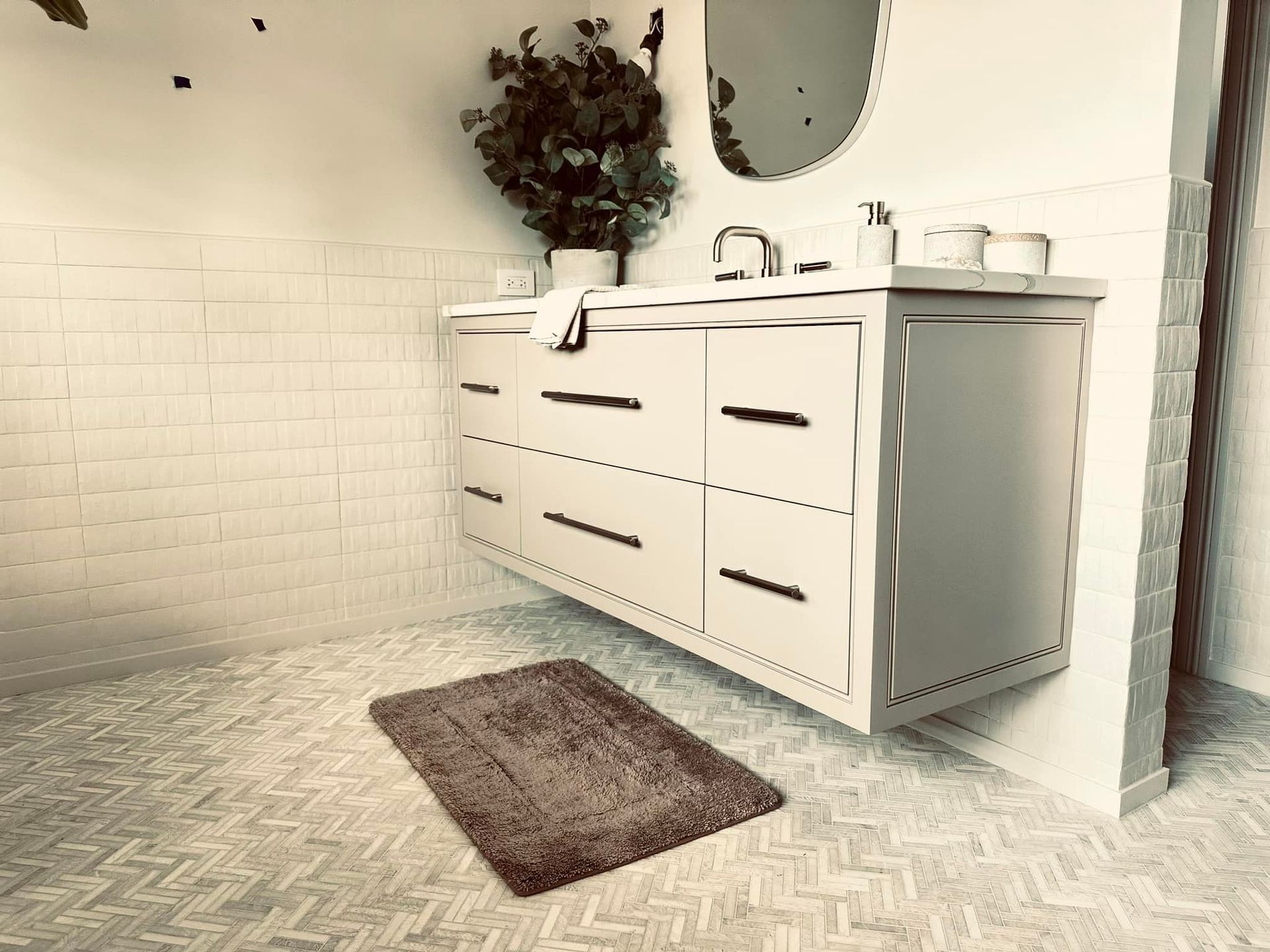 modern bathroom featuring a floating vanity with six drawers and black handles