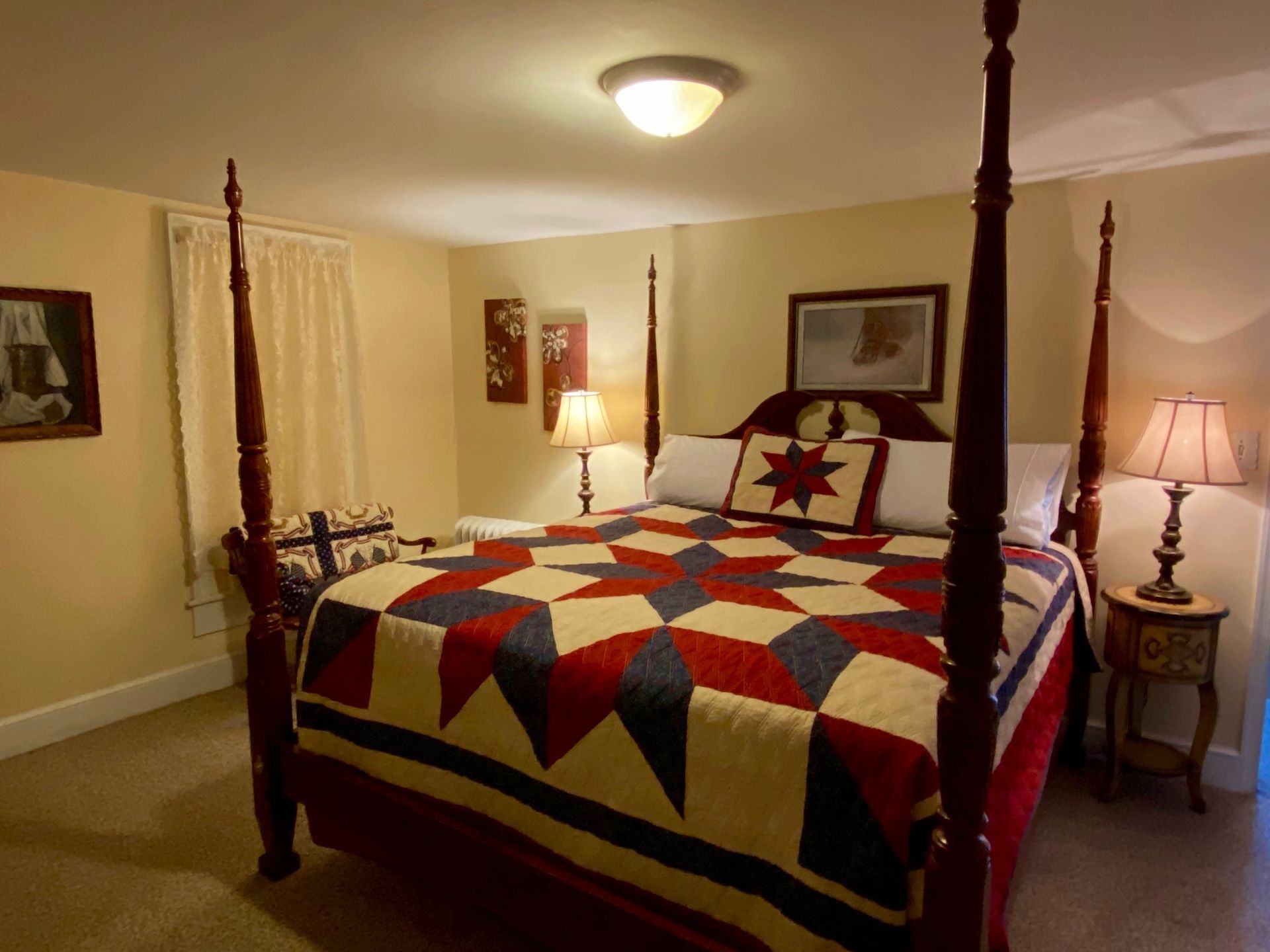 Canopy four-poster bed with colorful quilt in a warmly lit bedroom
