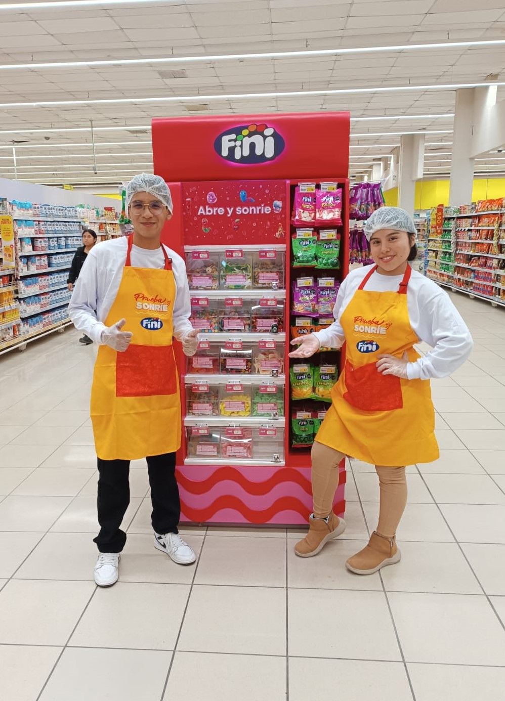 Dos personas con delantales amarillos de la marca Fini