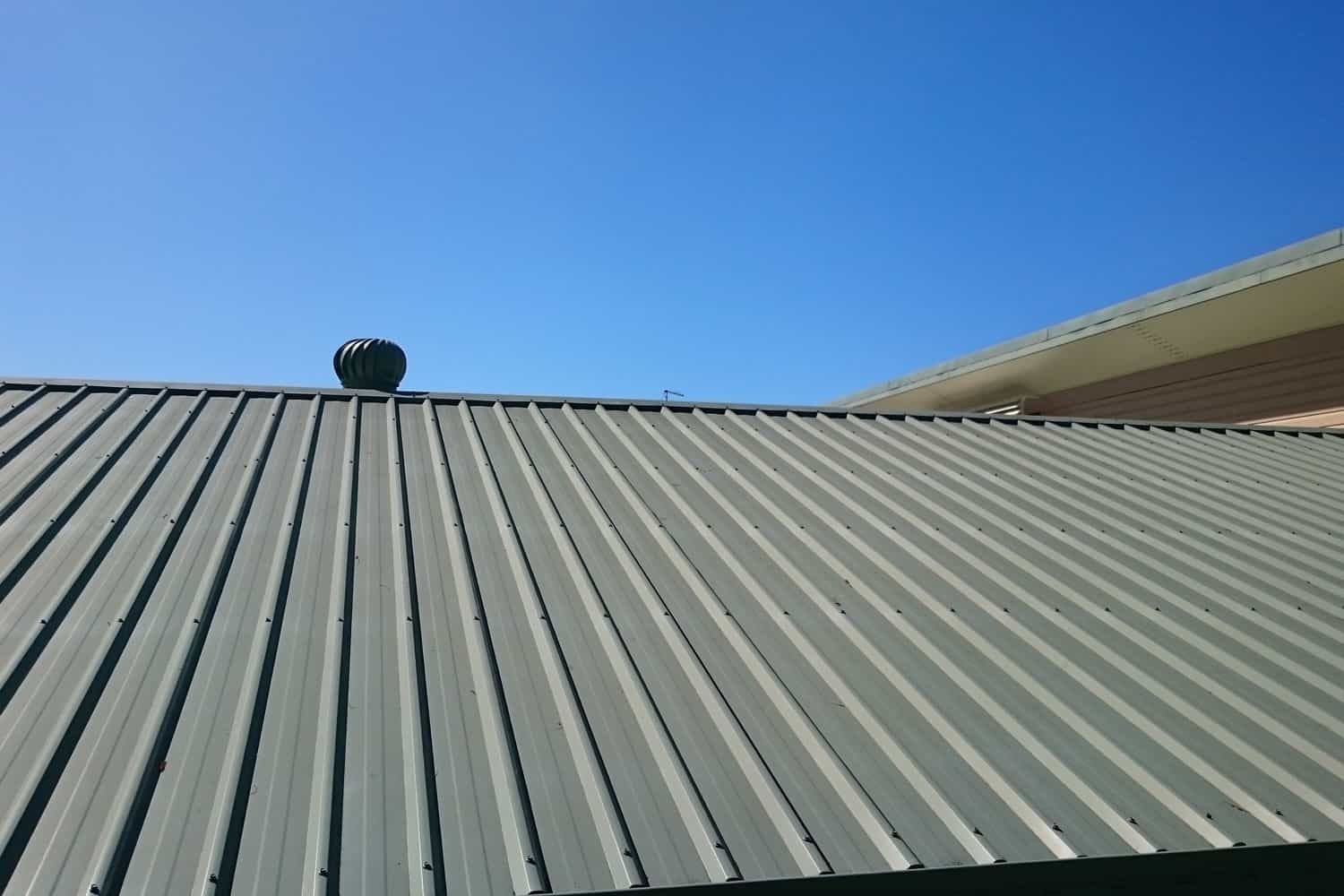 A roof with a fan on top of it and a blue sky in the background | Best roofing company in Nixa MO