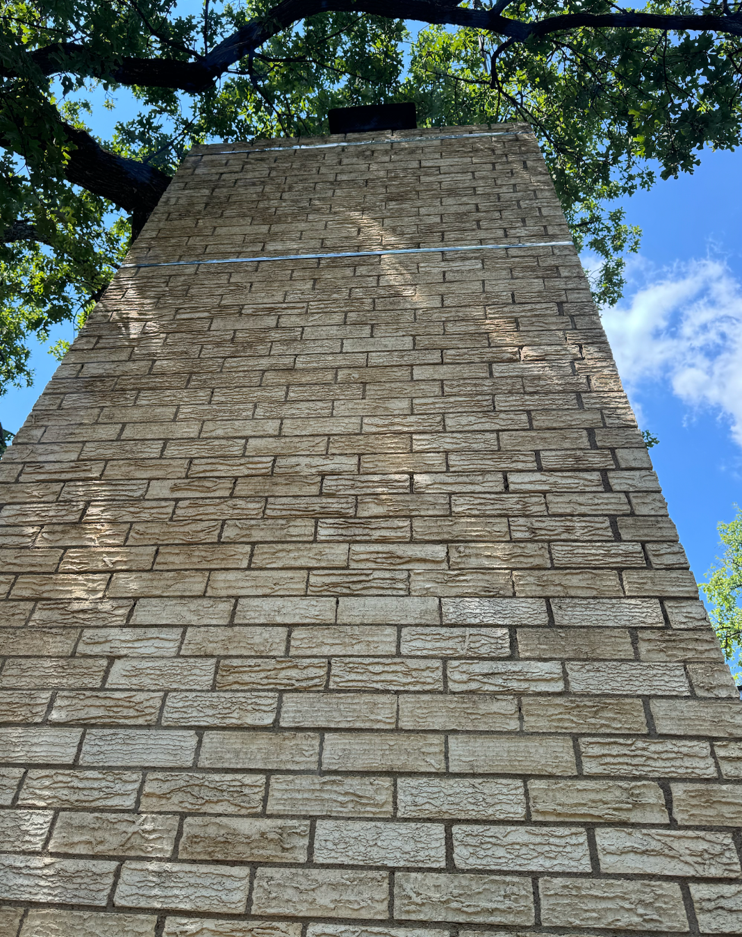 Looking up at a chimney on a brick wall