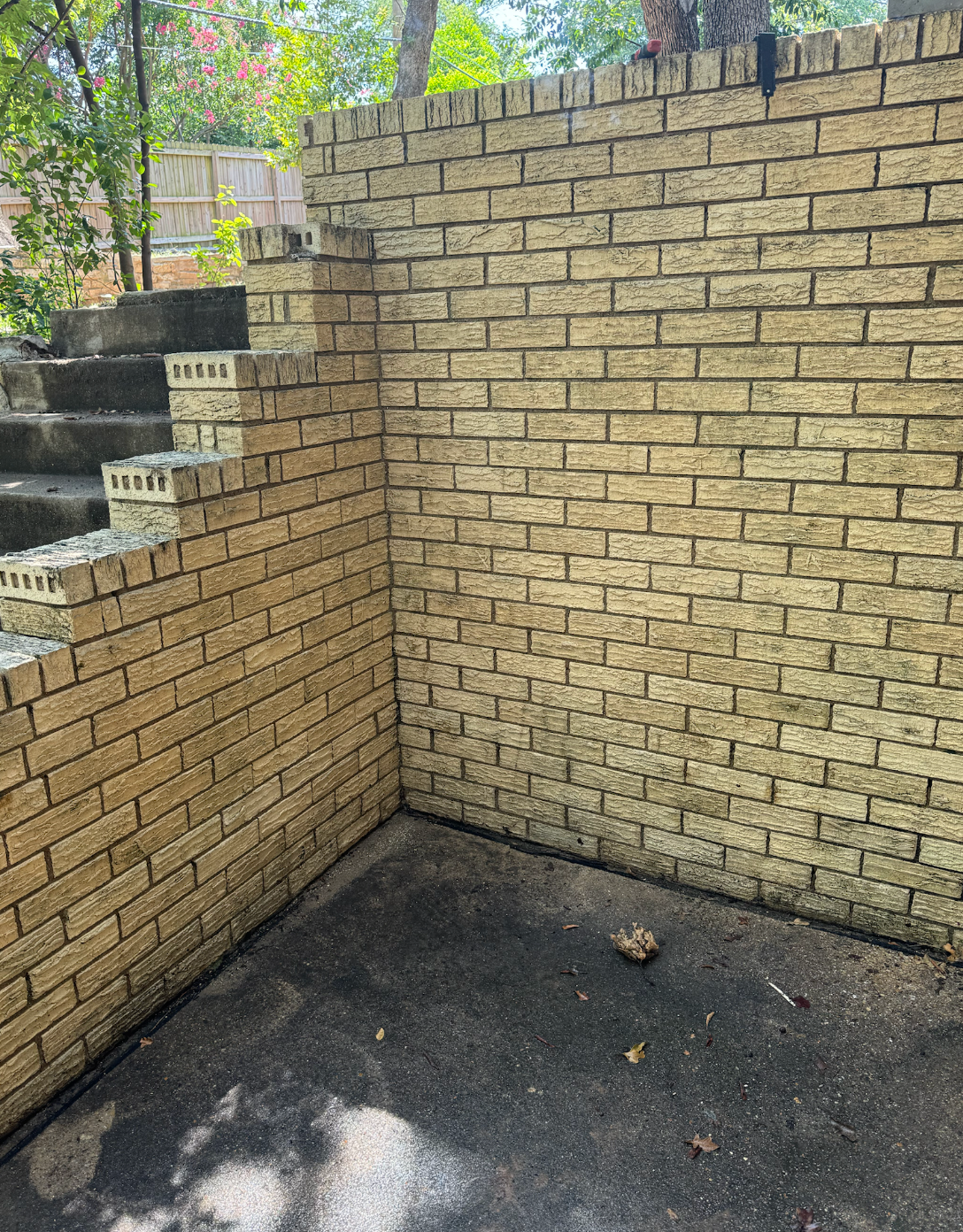 A brick wall with stairs leading up to it.