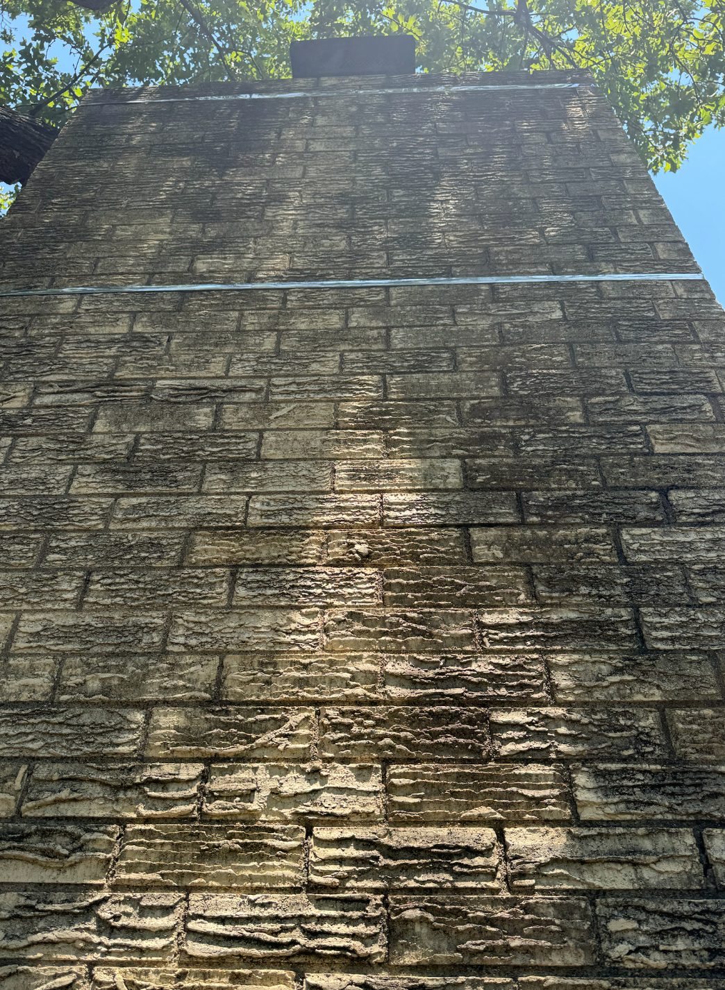A brick wall with a chimney on top of it.