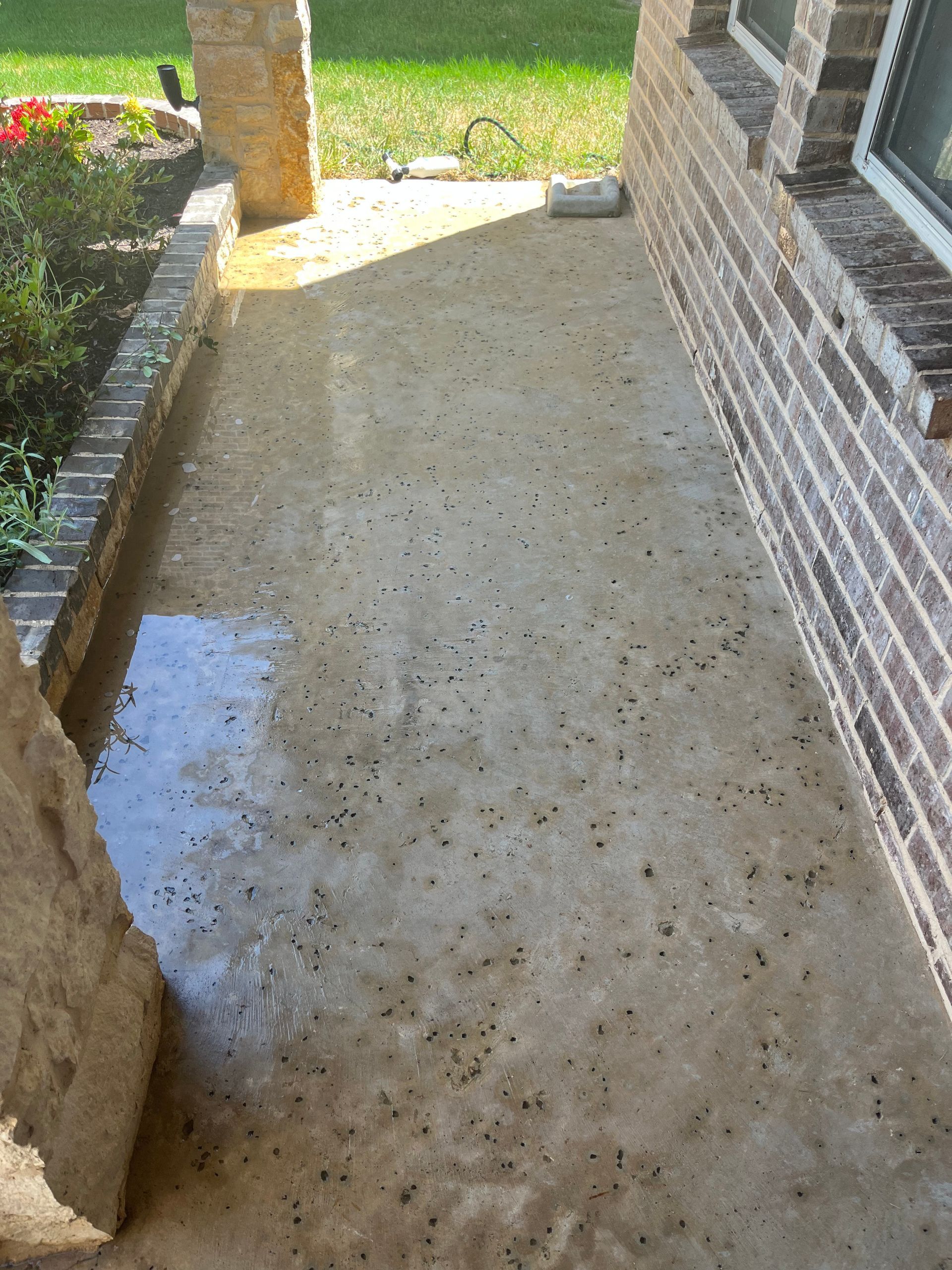 A dirty concrete walkway next to a brick building.