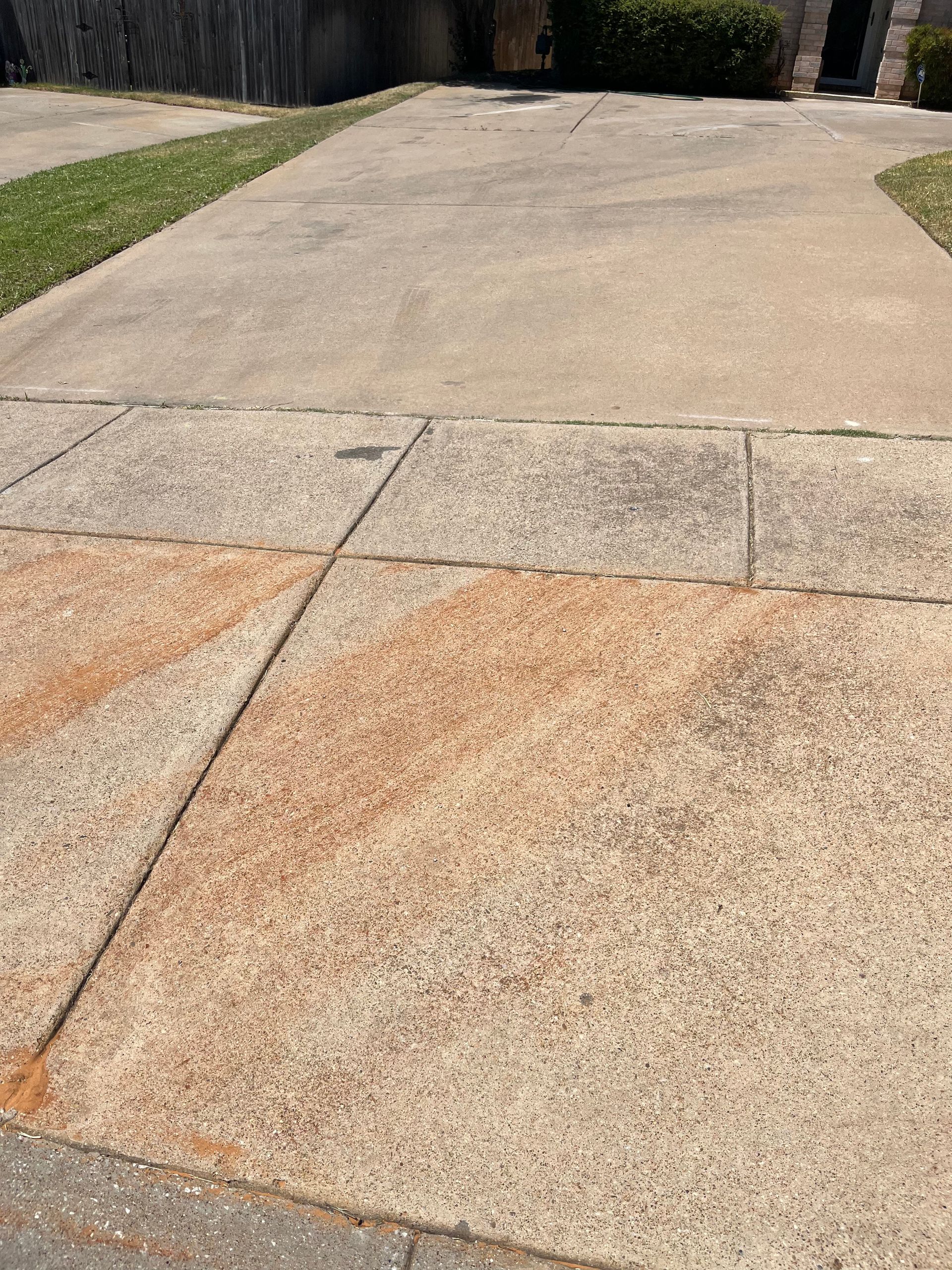 A concrete driveway with a lot of brown stains on it.