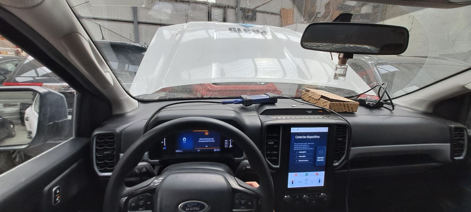 Vista interior del coche, salpicadero y volante con una pantalla táctil central que muestra los ajustes.